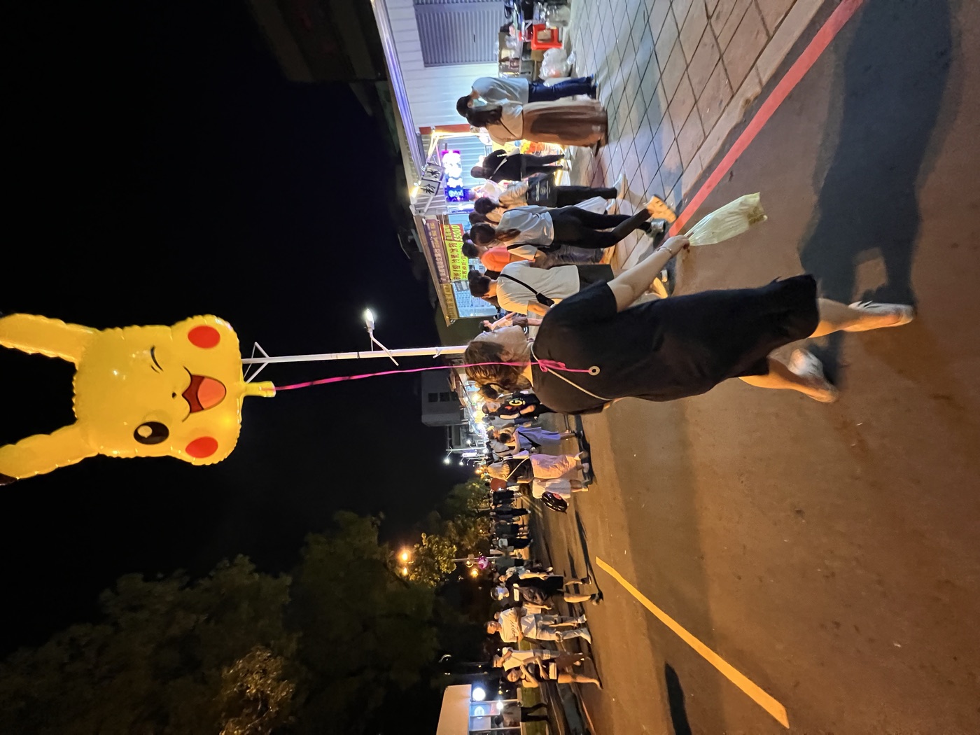咪咪牽著皮卡丘造型氣球逛夜市